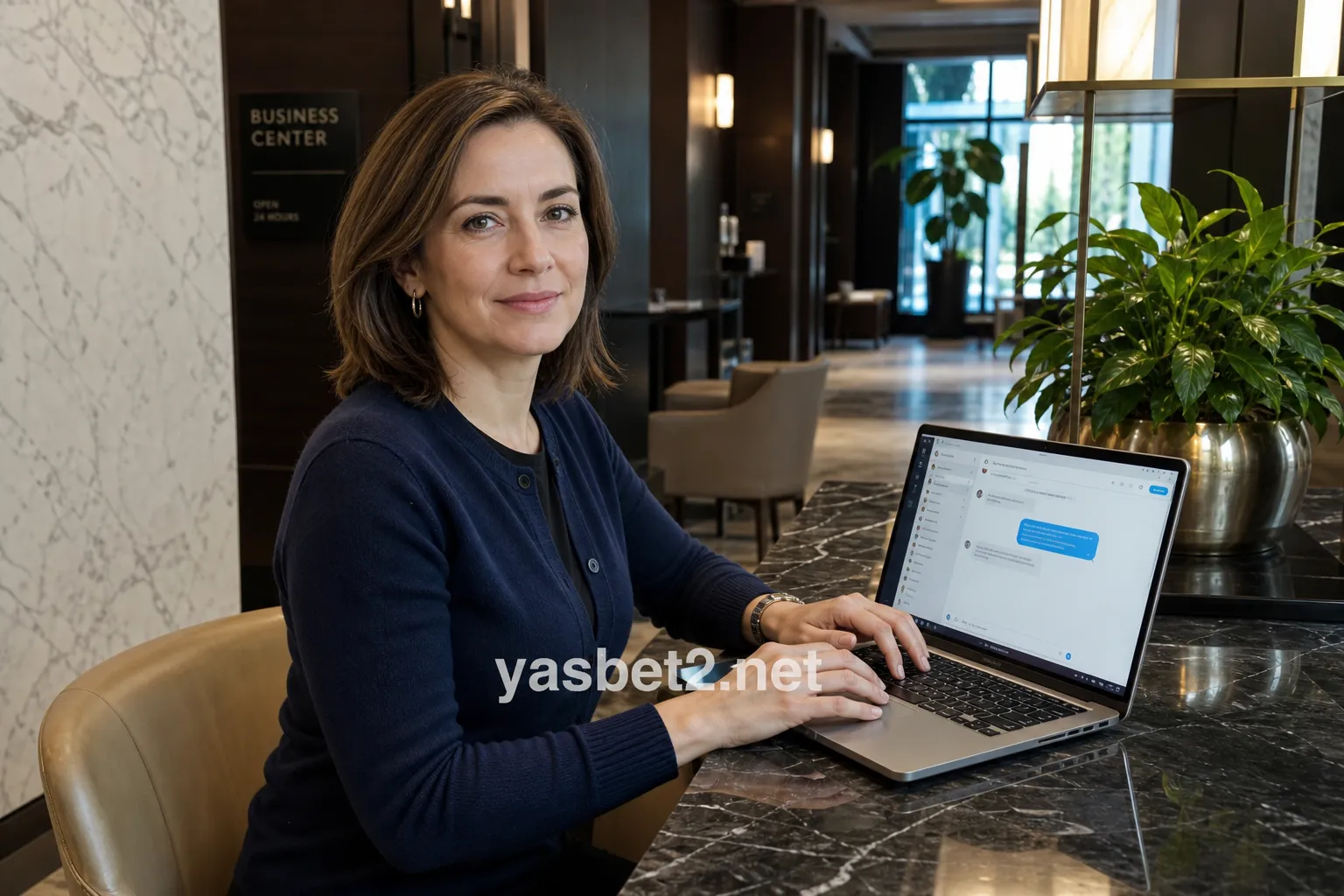 میز هتل با لپ‌تاپ روشن روی پنجره چت پشتیبانی